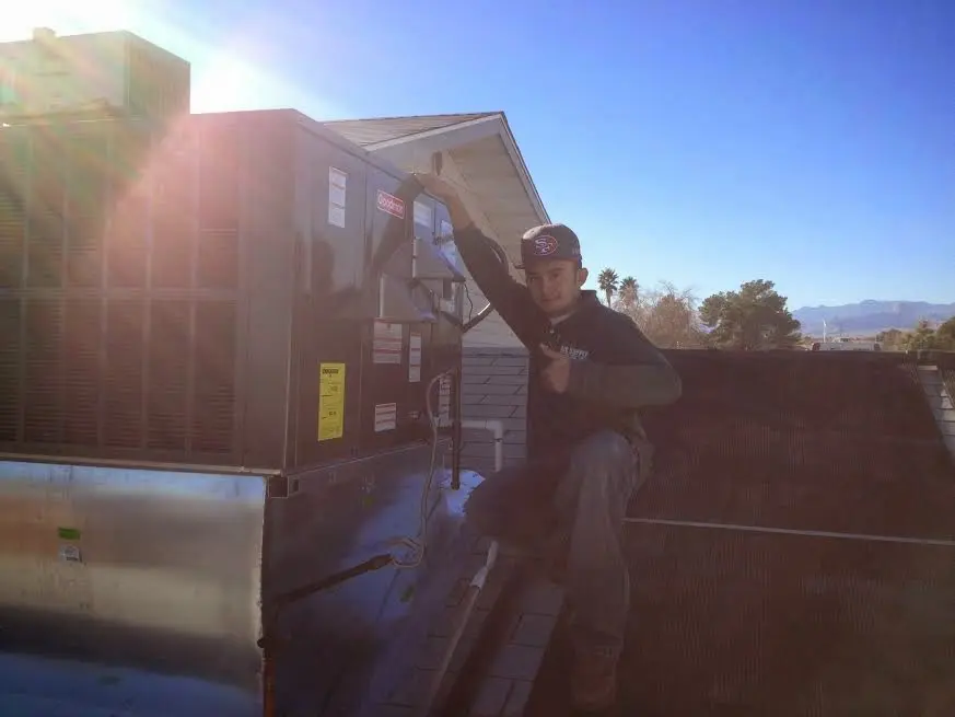 HVAC technician performing AC Tune-Up on a rooftop unit in West Long Branch